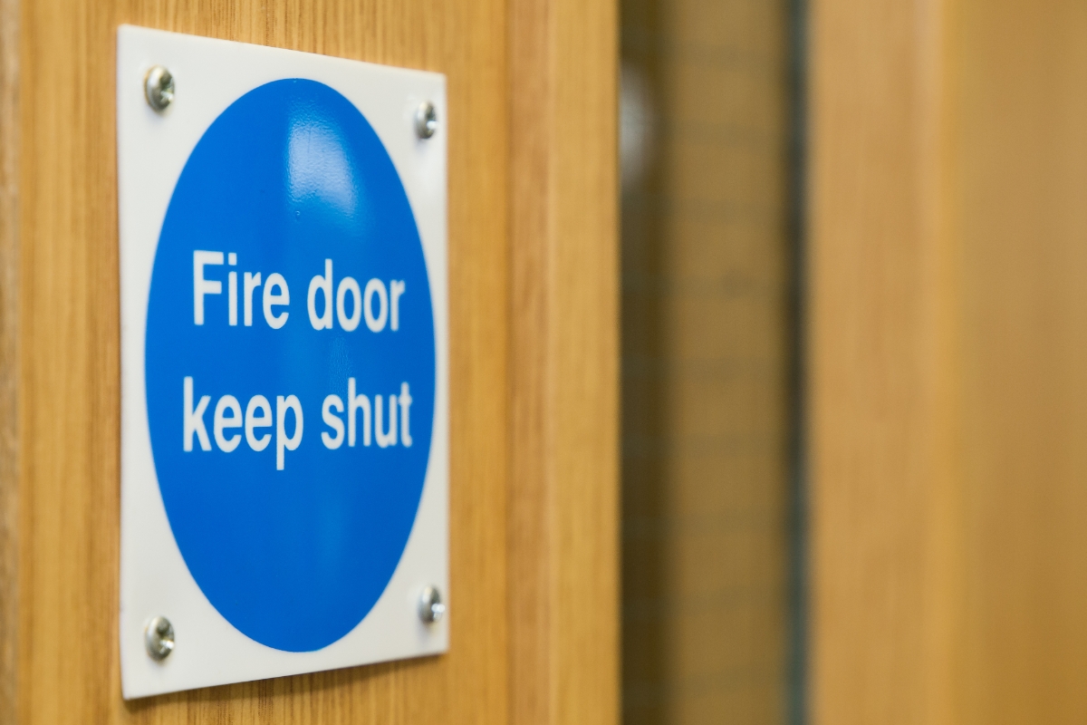 a 'Fire Door Keep Shut' sign on a wooden internal door